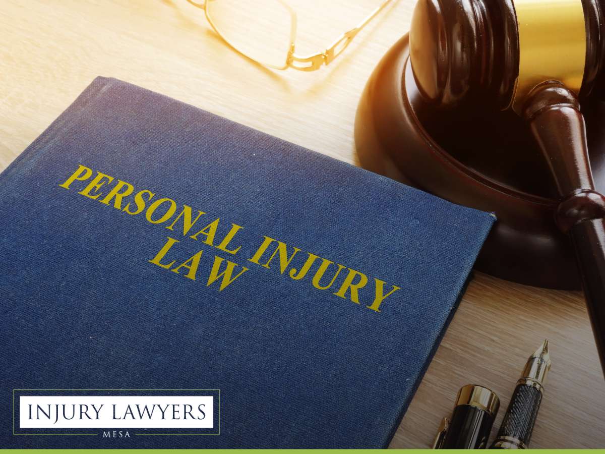 Book labeled 'Personal Injury Law' with a gavel, glasses, and pen, branded by Mesa Injury Lawyers
